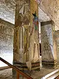A column with Osiris and Anubis depicted on it. Behind them, another column that had originally depicted Tausert, but was erased and repainted with a depiction of Setnakht.