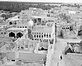 The houses of Qatif Castle are located amidst lush palm trees, with a vast ocean extending beyond the horizon. This photograph was taken from within the confines of Qatif Castle, although the exact date of capture remains uncertain.
