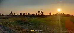 A cricket field near the Indus River bathed in sunset light.