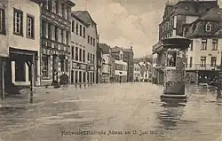 A black-and-white photograph of Adenauer Bach in June 1910. The river is wide and lined by three-floor buildings.