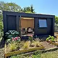 Modern Western garden room building featuring yakisugi wood cladding with sedum green roof