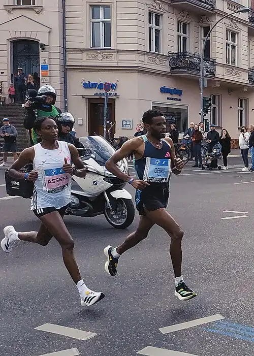 World record winner Tigst Assefa (left) about 25 km (16 mi) into the 2023 Berlin Marathon, alongside pacemaker Girmay Birhanu Gebru