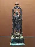 Silver standing Buddha under a parasol
