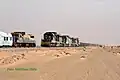 CC 102, 106 und 104 mit Erzzug bei der Kreuzung mit dem Le Train du desert im Bahnhof km 420 im Februar 2025