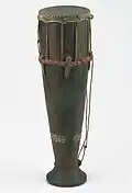 Tifa, Tanimbar Islands; the drum can be worn around the neck by means of a rattan band.