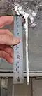 Calthemite soda straw growing from underside of concrete structure