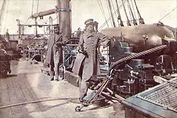 Captain Raphael Semmes, Alabama's commanding officer, standing aft of the mainsail by his ship's aft 8-inch smooth bore gun during her visit to Cape Town in August 1863. His executive officer, First Lieutenant John M. Kell, is in the background, standing by the ship's wheel.[10]