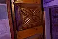 Hand-carved wooden door panel, depicting a four-leaved plant