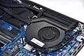 Centrifugal cooling fan installed within a laptop. The fan displaces air over the fin stack, which contains a pair of heat pipes.