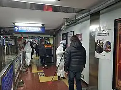 Subway staff in protective clothing check the temperature of a passenger with thermographic camera on January 27, 2020.
