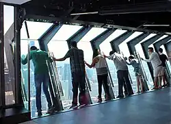 2014 daytime interior view of tourists on the TILT Thrill Ride, with the attraction in its outward-leaning position