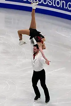 Maxime Deschamps lifts Deanna Stellato-Dudek above his head while performing on the ice.