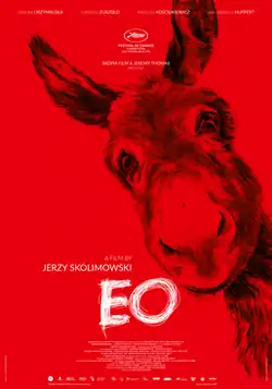 A red donkey is seen looking at the camera on a red background.