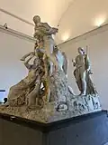 A side view showing a standing female figure that is obscured when the piece is viewed from the front.