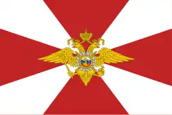 Flag of Internal Troops: a 2:3 white flag with rose madder cross pattée and emblem of Internal Troops in the center of it[2]