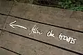 The trail is marked with metal direction signs, designed to look hand-written