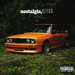 An orange BMW E30 M3 in plain sight amidst lush greenery.