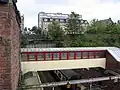 View down from the new road bridge showing the footbridge, with an eastbound train