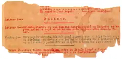 Torn piece of paper with typewritten text in red or black along the lines