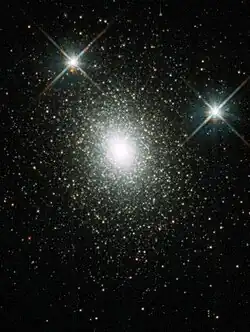 Thousands of stars clustered ever closer together towards a central core where they co-mingle to form a solid white central area.