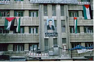 Assad's portrait with Ba'ath Party flags.
