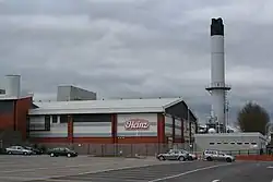 Image 3Heinz, although based in Hayes in Middlesex, has the largest food processing complex in Europe at a 55-acre (22&nbsp;ha) site at Kitt Green in Wigan, which produces 1.4&nbsp;billion cans of food each year; it is accessed to the east of the Orrell Interchange of the M6 (A577); the 38-acre Heinz NDC is next door (from North West England)