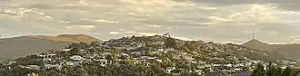 Huntsbury viewed from neighbouring St Martins. Also shown are the landmarks of Mount Vernon on the left and Te Heru o Kahukura / Sugarloaf and its transmitter on the right.
