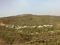 Hillside village surrounded by blossoming trees and green slopes