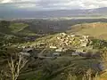 The village of Kovli nestled among rolling green hills and mountains