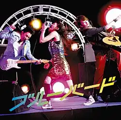 An image of two men and a woman performing on stage.