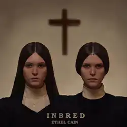 Two women in church attire face the camera; a cross appears in the background. The bottom reads the title: "Inbred" and the artist: "Ethel Cain"