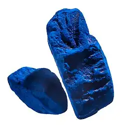 Close up of two lumps of solid indigo dye