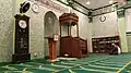 The prayer hall of the mosque, with the mihrab and wooden minbar visible.