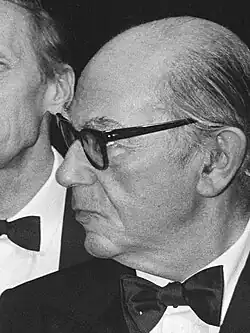 Black-and-white photo of a man with glasses wearing a suit and a bow tie