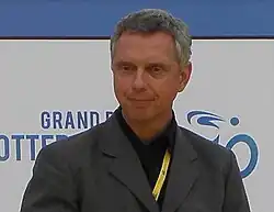 A man in a suit with a yellow lanyard.