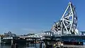 A photo of the Blue Bridge in front of the new Johnson Street Bridge, after removal of its road span