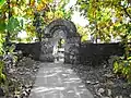 Temple enclosure wall and gate constructed using rubble stone masonry[14] with native teak trees
