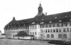 A black and white photograph of a three-storeyed building
