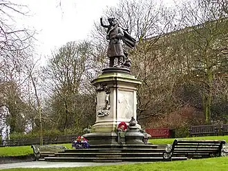 Statue on stone base in parkland