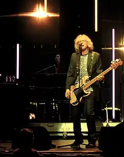 Mills singing and playing bass guitar with Stringfellow behind him on keyboards