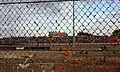 View of main grandstand from backstraight through clay on the crash fence.