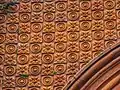 Terracotta tile work above the portico arches.