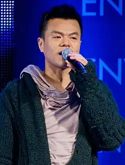 An image of Park Jin-young, holding a microphone.