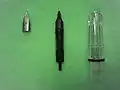 Parts of a Lamy Vista fountain pen. From left to right: Z 50 M nib (medium line width), ink feed, grip section of the barrel.