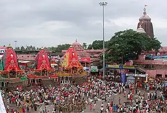 The Rath Yatra in Puri in modern times showing the three chariots of the deities with the Temple in the background