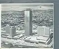 Original architectural rendering shows discrete buildings separated by outdoors plazas
