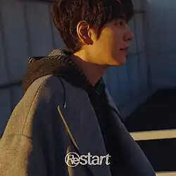 Man wearing a hoodie with sunset in the background