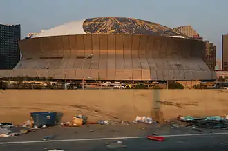 Photo taken from the I-10-US 90 junction showing most of the white rubber protective membrane over the roof of the Superdome torn away by strong winds during Katrina.