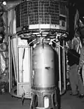 TIROS-2 satellite atop of launch vehicle, under hangar roof