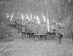 Black and white photograph of a group of men with saws in a forest